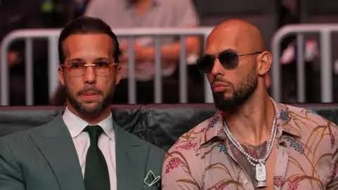 Andrew Tate and Tristan Tate sit side-by-side at a UFC match during a public appearance.