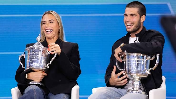 Aryna Sabalenka and Carlos Alcaraz standing on a tennis court during the 2026 US Open entry list announcement.