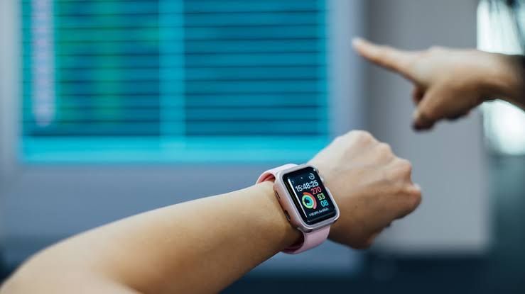 Traveler checking flight details on an Apple Watch at an airport terminal.