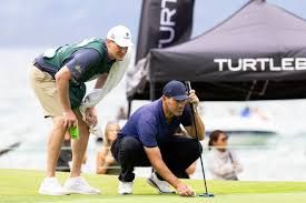 Tony Romo stands on a golf course, reflecting his recent professional challenges while his CBS contract status remains uncertain.