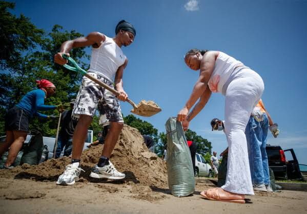Residents fill sandbags at a park in New Orleans in preparation for the arrival of Tropical Storm Bertha.