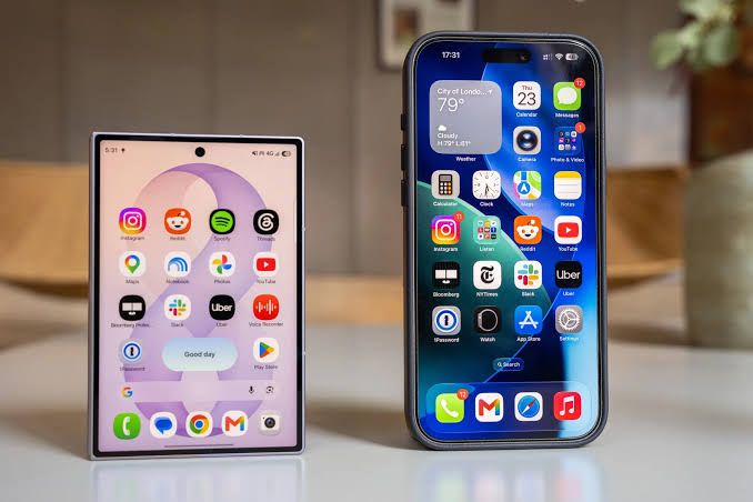 Samsung Galaxy Z Fold 8 held side by side with a standard smartphone to show the passport-like wider dimensions.