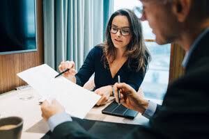 Two professionals reviewing legal documentation during a meeting in an office setting.