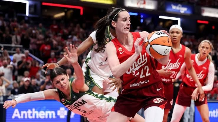 Caitlin Clark dribbling the basketball during an Indiana Fever game against the Seattle Storm at Gainbridge Fieldhouse.