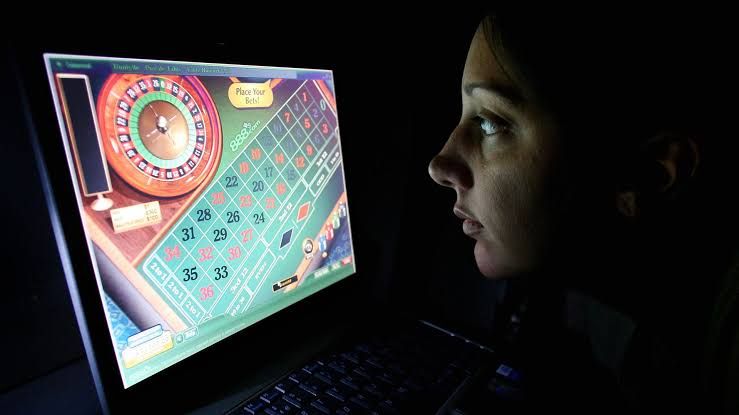 A person uses a smartphone to access an online gambling application during the late evening hours.