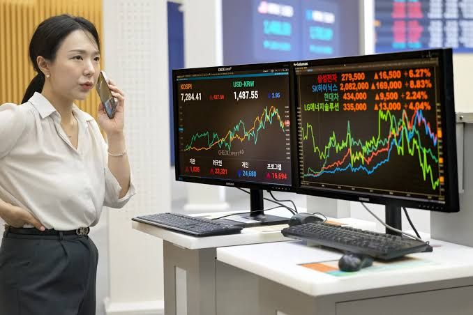 A digital stock market ticker board displaying declining values for major semiconductor companies in South Korea.