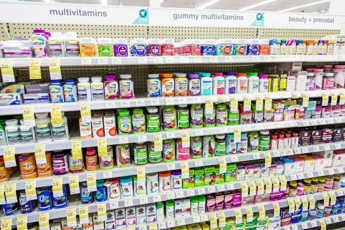 A close-up view of medicine bottles and supplies inside a hospital pharmacy cabinet.