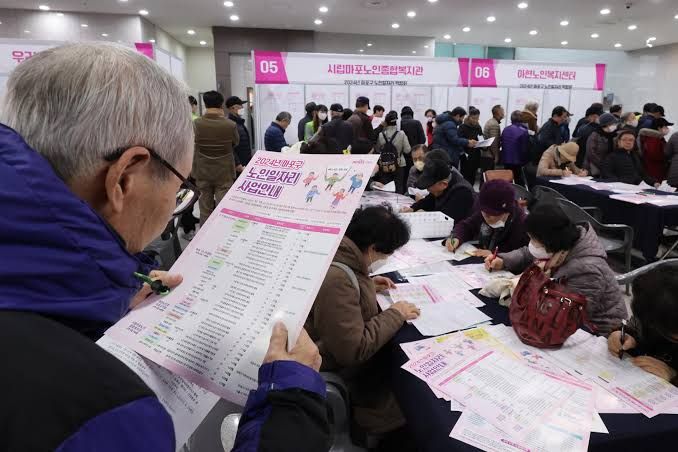 Job seekers at a fair for older workers in Seoul, representing the ongoing generational conflict in the labor market.