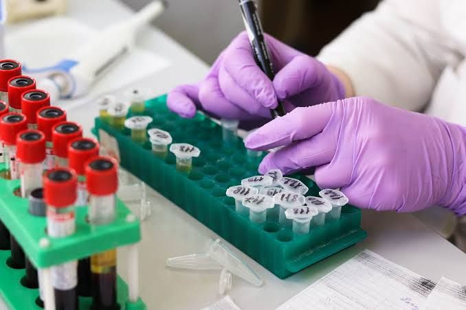 A scientist reviewing genetic sequencing data on a high-resolution display in a clinical laboratory setting.